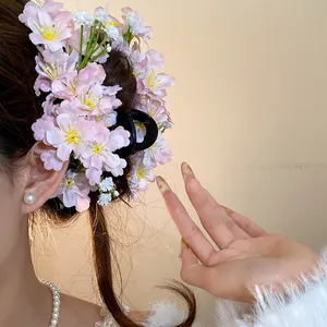 Detailed view of handmade pink fabric flower hair clip showing delicate petal textures.