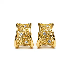 Orecchini geometrici dorati stile vintage con filigrana e pietre scintillanti.