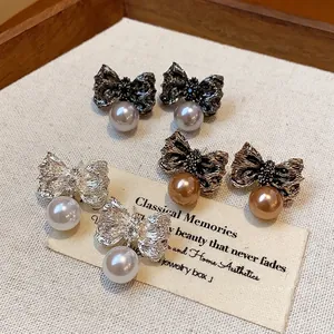 Textured bowknot earrings with pearl drops in gold, silver, and charcoal tones