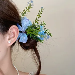 Forest style fabric flower hair clip with elegant blue petals and green leaves on hair