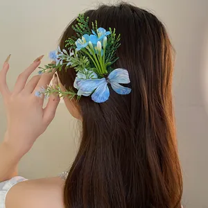 Close-up of elegant fabric flower hair clip with blue butterfly detail on brown hair