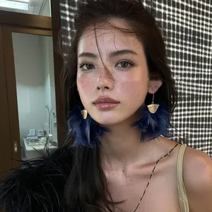 Close-up of elegant dark blue feather fringe drop earrings for a stylish fashion look