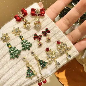 Close-up of festive Christmas earrings with tree, snowflake and bow designs on a sleeve