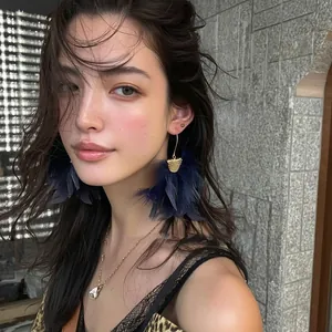 Close-up of elegant navy blue feather tassel hook earrings worn by a fashion model
