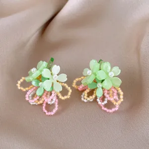 Close-up of colorful dopamine-style flower earrings with delicate bead loops