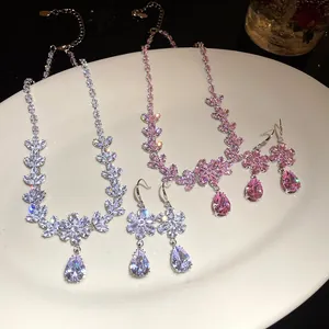 Dettaglio del set collana e orecchini a goccia con fiori di zircone in bianco e rosa