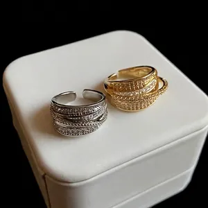 Elegant multi-layer zircon geometric open rings in gold and silver finishes on a white box
