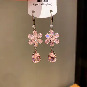Dettaglio ravvicinato di eleganti orecchini a fiore in zirconia rosa con pendenti