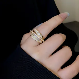 Close-up of a multi-layer gold open ring with sparkling zircon stones on finger