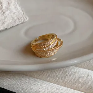 Detailed close-up showing the intricate multi-layer zircon geometric open ring in gold