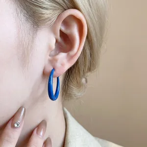 Klein blue hoop earrings with silver needles in a retro minimalist fashion style