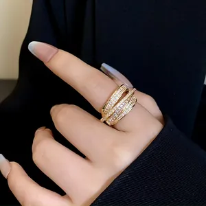 Close-up of a luxurious gold multi-layer ring with sparkling zircon pavé on a hand