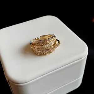 Close-up detail of the sparkling zircon arrangement on a gold-plated multi-layer open ring