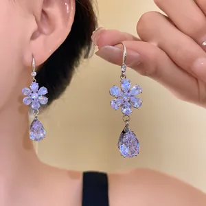 Dettaglio ravvicinato di orecchini a forma di fiore con pendenti in zircone a goccia scintillanti