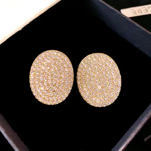 Gros plan détaillé de boucles d'oreilles ovales serties de strass étincelants