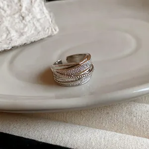 Close-up detail of an elegant multi-layer silver open ring with sparkling zircon pavé stones