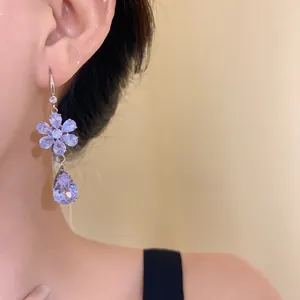 Dettaglio di eleganti orecchini con zirconia lavanda a forma di fiore e goccia