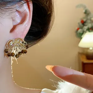 Detailed macro shot of vintage firework stud earrings with tiger eye stone tassels