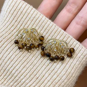 Detailed macro shot of vintage firework-style earrings with tiger eye stone tassels