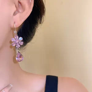Elegante primo piano di orecchini a fiore in zircone rosa sull'orecchio di un modello