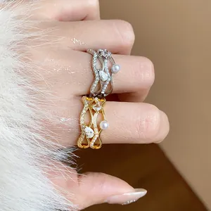 Detailed view of wavy rings with pearls and cubic zirconia in gold and silver plating.