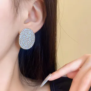 Gros plan d'élégantes boucles d'oreilles ovales géométriques serties de strass étincelants