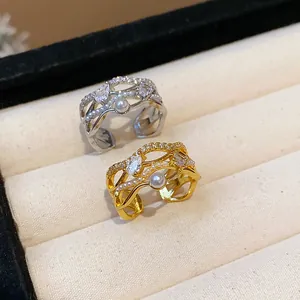 Close-up view of gold and silver rings with pearls and cubic zirconia in a jewelry box