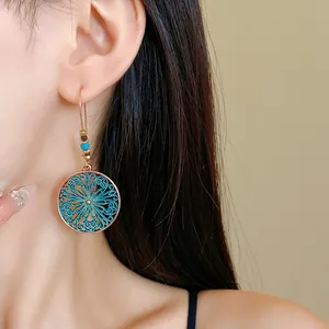 Close-up of bohemian round filigree earring with turquoise oil-drip detail on model