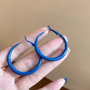 Close-up of vibrant Klein Blue thick hoop earrings with smooth glossy finish