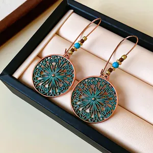 Close-up view of vintage round filigree earrings with blue beads and copper finish