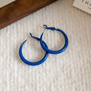 Detail showing the vibrant Klein blue finish of these minimalist hoop earrings.