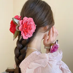 Detalle de una pinza para el pelo con flor de tela rosa en un peinado con trenza larga