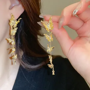 Detailed view of elegant gold butterfly tassel earrings with shimmering crystals.