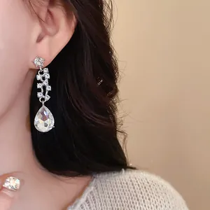 Gros plan de boucles d'oreilles en strass argenté avec grand cristal goutte d'eau