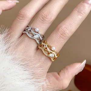 Macro detail of 18k gold-plated intertwining wave rings featuring pearls and pavé zircons