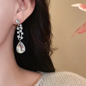 Gros plan de boucles d'oreilles en goutte d'eau avec strass pour mariée chic