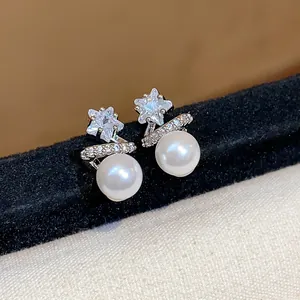 Macro view of elegant star zircon earrings with lustrous white pearls and silver posts