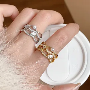 Detailed macro view of 18k gold plated wave rings with pearls and sparkling zircons