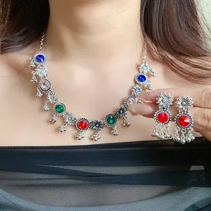 Detailed view of vintage silver floral necklace and earrings with colorful crystals