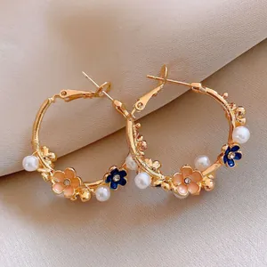 Elegant gold-toned hoop earrings with peach enamel flowers and white faux pearls