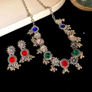 Detail view of vintage court-style necklace and earrings set with colorful crystals