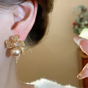 Primo piano di un elegante orecchino a fiore dorato con perla indossato sull'orecchio