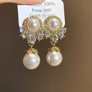 Detailed view of vintage court style earrings with pearls and rhinestones