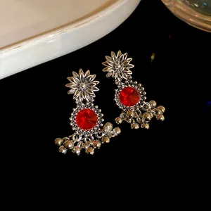 Detailed shot of vintage court style flower earrings with red rhinestones and beads
