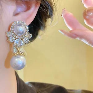 Close-up detail of vintage royal style gold-tone pearl and crystal drop earrings