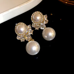 Close-up of vintage royal style earrings with white pearls and sparkling rhinestones