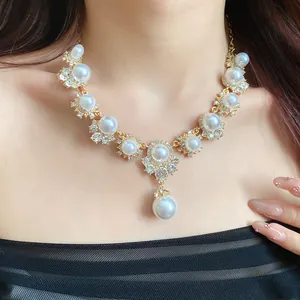Close-up of vintage palace style necklace with pearls and rhinestones on a model.