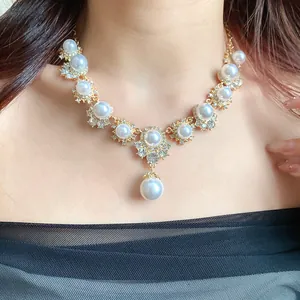 Detail shot of elegant vintage pearl necklace with rhinestone flower pendant on model