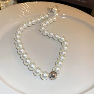 Primo piano di una collana di perle retrò francese con una singola perla metallica.
