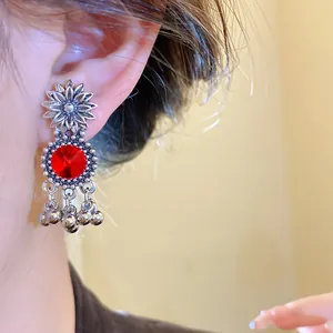 Macro detail of vintage court style flower earring featuring red crystal and silver beads